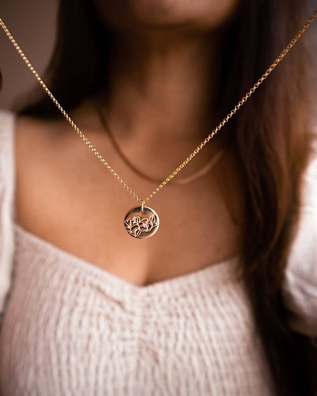 Australian Birth flower necklace for January held by a woman